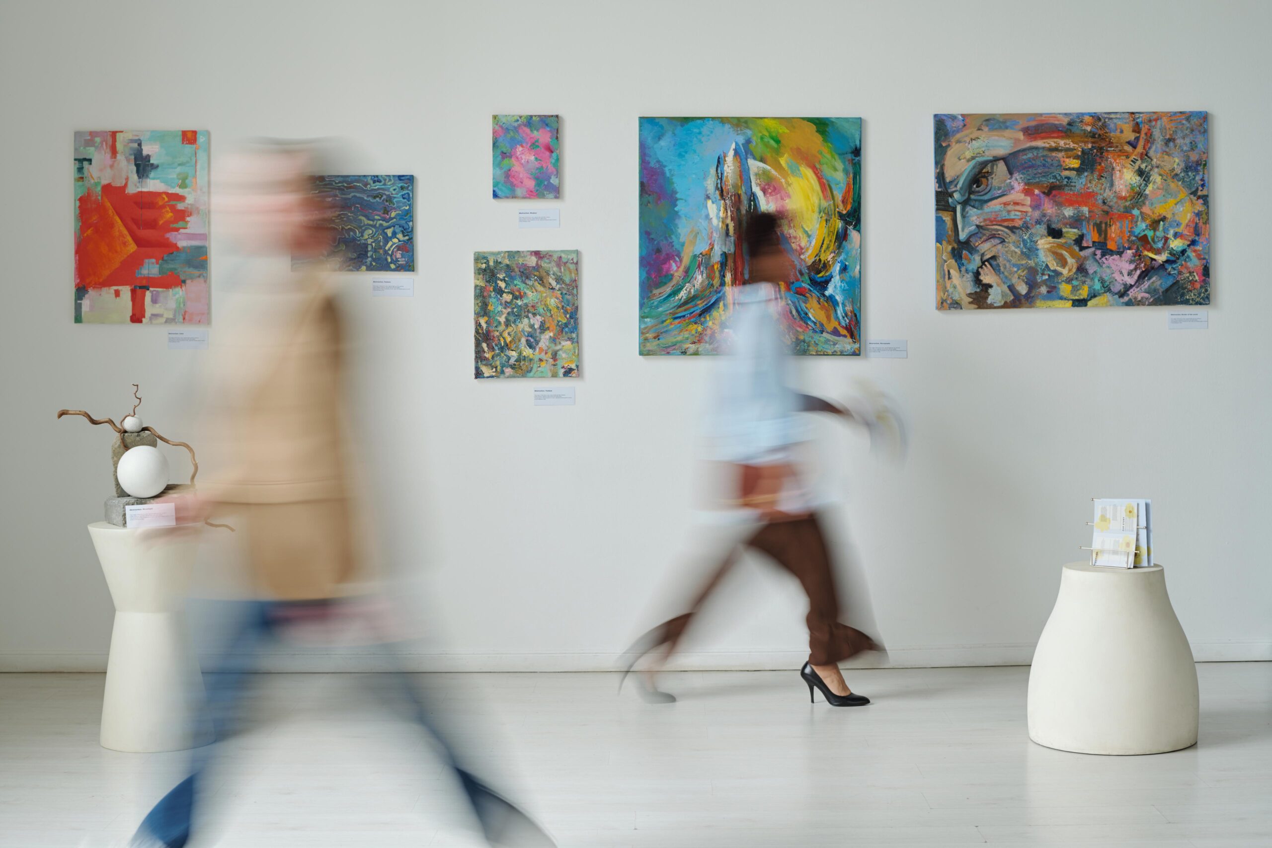 Interno di un museo con quadri e sculture esposte e visitatori